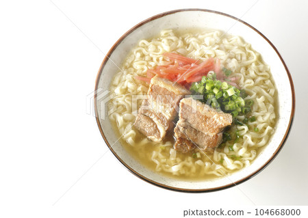 A bird's-eye view of hot Okinawa soba with pork ribs, plenty of small green onions, and red pickled ginger on a white background 104668000
