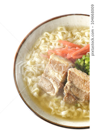 A bird's-eye view of hot Okinawa soba with pork ribs, plenty of small green onions, and red pickled ginger on a white background 104668009