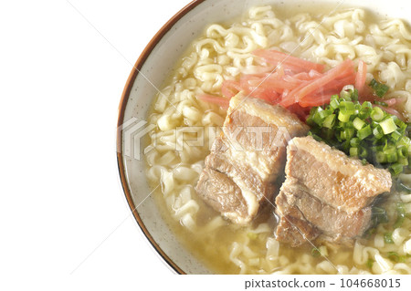 A bird's-eye view of hot Okinawa soba with pork ribs, plenty of small green onions, and red pickled ginger on a white background 104668015