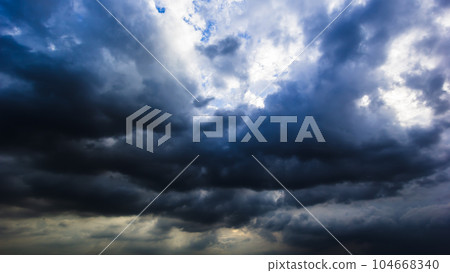 The dark sky with heavy clouds converging and a violent storm before the rain.Bad or moody weather sky and environment. carbon dioxide emissions, greenhouse effect, global warming, climate change 104668340