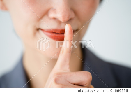 A young woman with her finger on her mouth Business image 104669316