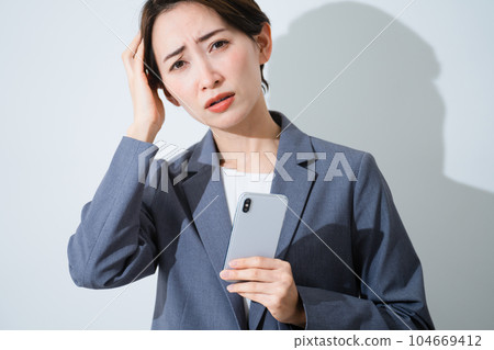 一位拿著智能手機而擔心的年輕女性的商業形象 104669412