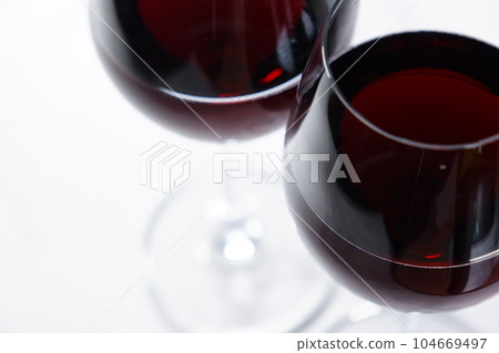 Two wine glasses filled with red wine Two wine glasses filled with red wine 104669497