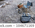Breakfast at a winter campsite, two burners, chairs and a wooden basket on the ground 104671169