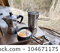 A frying pan with a fried egg on the wood stove inside the tent, a coffee press and a cooker 104671175