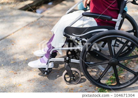 Nursing home. Young caregiver helping senior woman in wheelchair. Nursing home. Young caregiver helping senior woman in wheelchair. 104671304