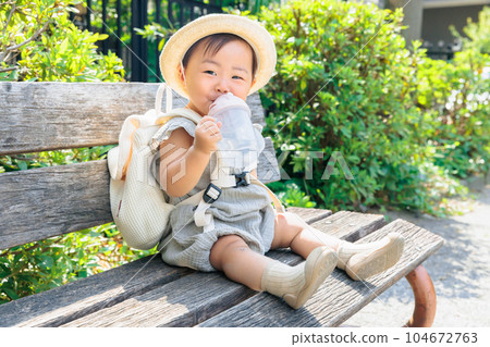 寶寶坐在長凳上補水 104672763