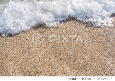 A soft wave runs on a sandy shore on a summer day. Empty space can be used as background for display or montage your top view products. 104673202