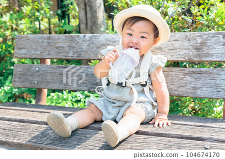 寶寶坐在長凳上補水 104674170