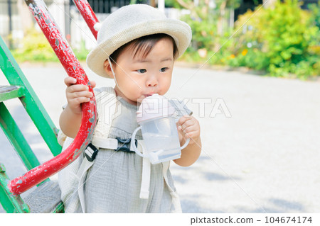 Park play on a sunny day Baby taking a break Rehydration Park play on a sunny day Baby taking a break Rehydration 104674174