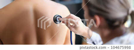 Female doctor examining breath of patient using stethoscope 104675998