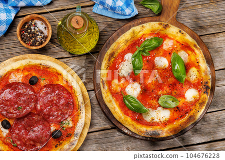 Margarita and pepperoni pizza with tomatoes, mozzarella cheese and basil Margarita and pepperoni pizza with tomatoes, mozzarella cheese and basil 104676228