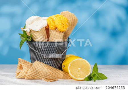 Refreshing ice cream in waffle cones with lemon flavour Refreshing ice cream in waffle cones with lemon flavour 104676253