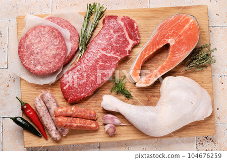 Various raw meat and fish. Steaks, sausages, salmon, chicken and spices 104676259