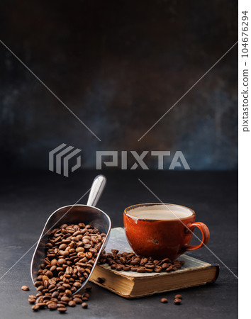 Rich coffee in a cup with aromatic roasted beans 104676294