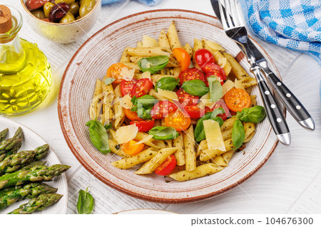 Italian pasta adorned with fresh tomatoes and aromatic basil 104676300