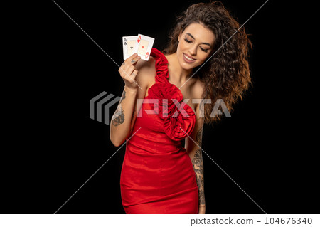 Happy brunette demonstrating set of winning cards from pair of aces Happy brunette demonstrating set of winning cards from pair of aces 104676340