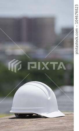 Helmet and cityscape | Construction industry / manufacturing industry image Helmet and cityscape | Construction industry / manufacturing industry image 104676823