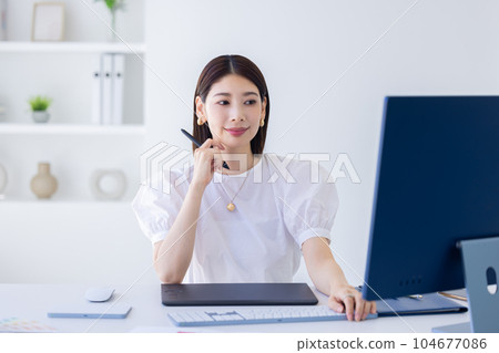 A woman working at a business desk A woman working at a business desk 104677086