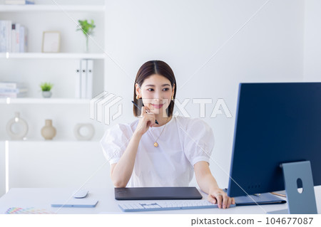 A woman working at a business desk 104677087