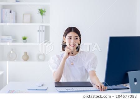 A woman working at a business desk A woman working at a business desk 104677088