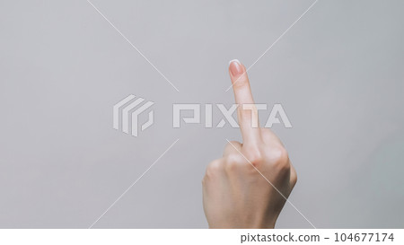 Middle finger. Rude gesture. Woman hand showing impolite sign offensive insulting behavior isolated on gray empty space background. 104677174