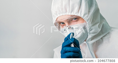 Healthcare virologist. Medical examination. Female doctor woman in white ppe suit pointing pen with watching you gesture isolated on grey background empty space. 104677808