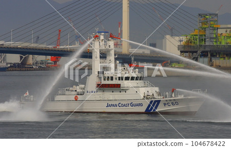 Patrol Low PC60 "Minoo" displaying water discharge for sea surface protection during disaster drills 104678422