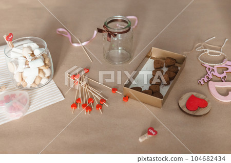 sweet gift for Valentine's Day with your own hands. A gift for the holiday made of heart-shaped candies and marshmallows 104682434