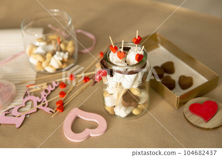 sweet gift for Valentine's Day with your own hands. A gift for the holiday made of heart-shaped candies and marshmallows 104682437