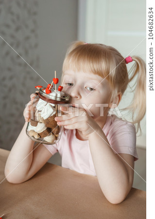 A little girl blogger makes a sweet Valentine's Day gift with her own hands. A gift for the holiday, a video blog entry. 104682634