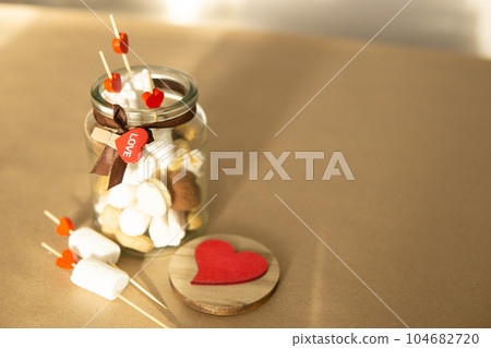 sweet gift for Valentine's Day with your own hands. A gift for the holiday made of heart-shaped candies and marshmallows sweet gift for Valentine's Day with your own hands. A gift for the holiday made of heart-shaped candies and marshmallows 104682720