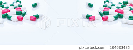 Capsules pill spread on white background. Prescription drugs. Capsule pill frame banner. Green, pink, and white color capsule pills. Pharmaceutical industry. Medication and pharmacology. Health care. 104683485