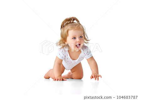 Beautiful, little, baby girl in diaper crawling on floor, playing against white studio background. Happy, smiling toddler Beautiful, little, baby girl in diaper crawling on floor, playing against white studio background. Happy, smiling toddler 104683787