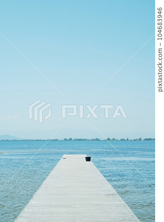 weathered wooden pier leading to the water 104683946