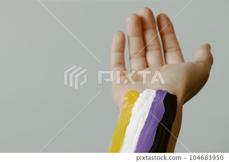 person with a non-binary flag painted in their arm 104683950