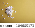 White Pills On Orange Surface 104685173