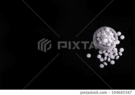 White Pills On Black Surface 104685387