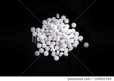 White Pills On Black Surface 104685388