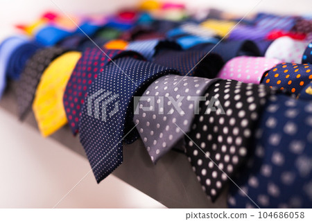 row of Neckties on hangers in men clothing store row of Neckties on hangers in men clothing store 104686058