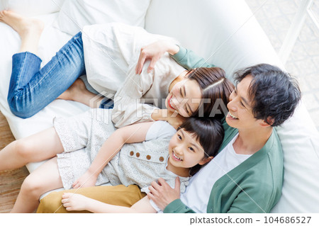 Family relaxing on the sofa in the living room 104686527
