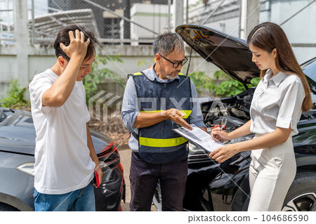 Car insurance agent showing his female client where to sign the accident insurance claim form while the guilty man standing near them 104686590