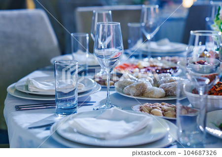 Setting the festive table. empty glasses and snacks on the table.  104687326