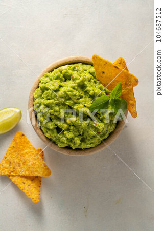 Guacamole avocado mash dip, with tortilla chips and fresh avocados 104687512