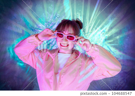 Cool teenager. Fashionable girl in pink sport trendy jacket and vintage retro sunglasses enjoys style of 80s - 90s vibes. Teenager Girl at disco party. Young fashion model on shiny foil background. Cool teenager. Fashionable girl in pink sport trendy jacket and vintage retro sunglasses enjoys style of 80s - 90s vibes. Teenager Girl at disco party. Young fashion model on shiny foil background. 104688547