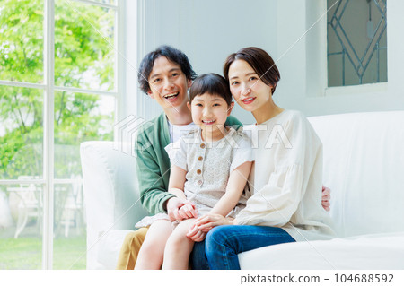 Close family sitting on the sofa in the living room 104688592