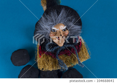 Witch Befana and coal pieces for naughty kids on blue background. Italian Epiphany day tradition. Witch Befana and coal pieces for naughty kids on blue background. Italian Epiphany day tradition. 104688641