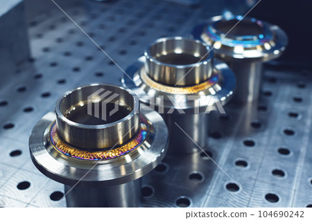 New freshly welded stainless steel flanges. Demonstration of reference multi-colored seams New freshly welded stainless steel flanges. Demonstration of reference multi-colored seams 104690242