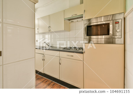 a kitchen with white cabinets and black counter tops on the floor in front of an oven, microwave and dishwasher 104691155