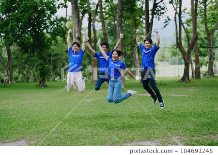 Volunteers of various nationalities are showing solidarity, donating their personal time, holding black trash bags to collect plastic waste for recycling to reduce pollution in a public park Volunteers of various nationalities are showing solidarity, donating their personal time, holding black trash bags to collect plastic waste for recycling to reduce pollution in a public park 104691248